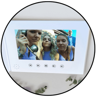 Weißes Videobuch von Dein Videofon mit integriertem Bildschirm – zeigt emotionale Videoaufnahmen von Hochzeitsgästen als digitale Erinnerung zum Anfassen.