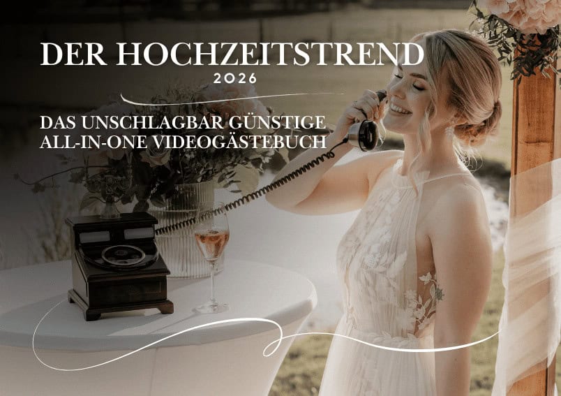 Eine Braut in einem weißen Hochzeitskleid lächelt, während sie ein Retro-Telefon in der Hand hält. Sie steht an einem Tisch mit einem Vintage-Telefon; ein deutscher Text wirbt für einen Hochzeitsvideo-Gästebuch-Trend für 2026.