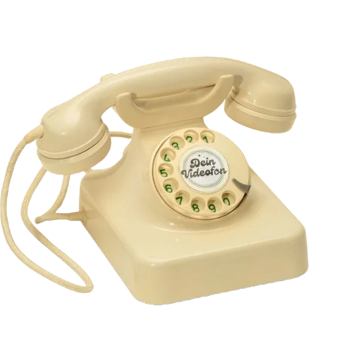 Ein beiges Wählscheibentelefon mit einer aufgewickelten Schnur und der Aufschrift Dein Videofon in der Mitte der Wählscheibe.